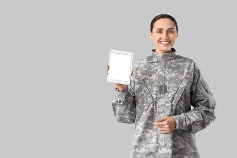 Female soldier with blank tablet computer on light background Stock Photos