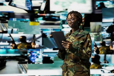 Female soldier in command center using tablet to monitor intelligence feeds Stock Photos