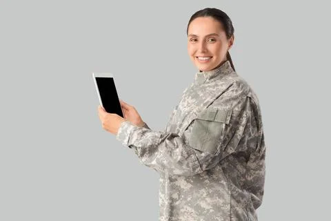 Female soldier with tablet computer on light background 写真素材