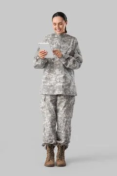 Female soldier with tablet computer on light background 写真素材