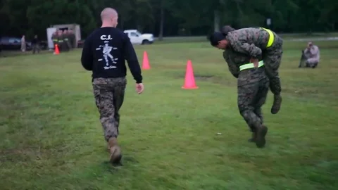 Female soldiers in basic training do lifesaving exercises on an outdoor field. Stock Footage 74799652