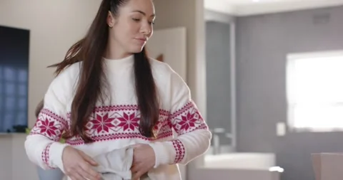Female sorting clothes, folding and placing sweaters into labeled Donations box Stock Footage 345588209