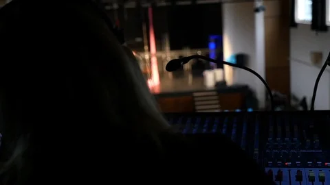 Female sound engineer behing a mixing console in a concert hall Stock Footage 129406369