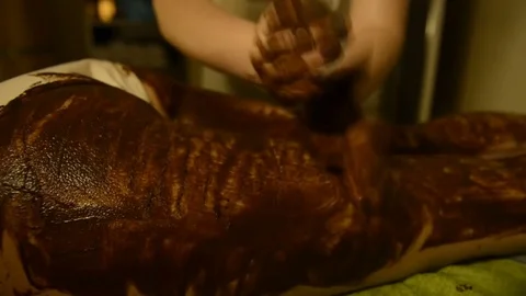 Female Spa client receiving massage chocolate therapy 動画素材 75368207