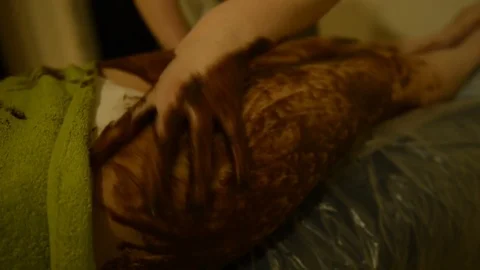 Female Spa client receiving massage chocolate therapy 動画素材 75368466