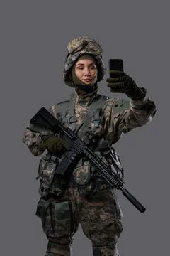 Female special forces soldier with cellphone against grey background Stock Photos