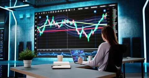 Female Stock Analyst Analyzing Data on Computer Screens Foto stock