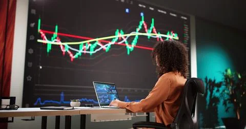 Female Stock Analyst Analyzing Data on Computer Screens Foto stock