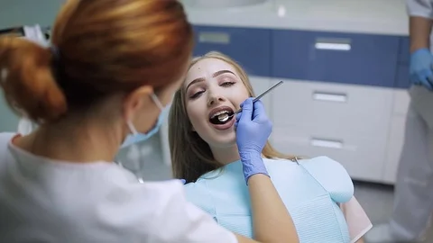Female stomatologist in mask. Woman doctor working. Patient looking in the Stock Footage