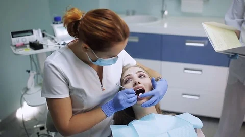 Female stomatologist in mask. Woman doctor working. Patient looking in the Stock Footage