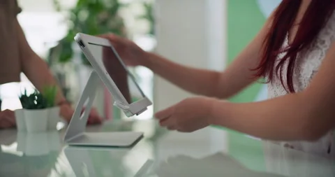 Female store owner completing purchase with customer using a tablet in interior Stock Footage 199456741