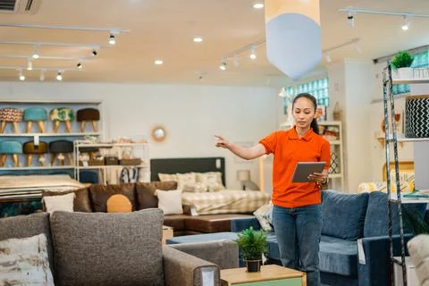 Female store supervisor checks using a tablet while standing Stock Photos