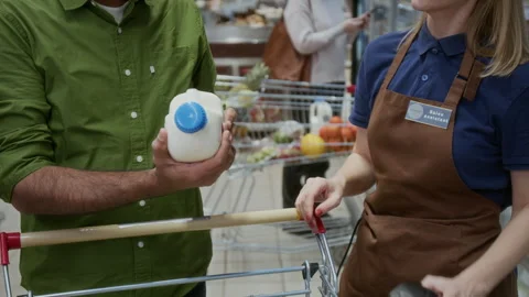 Female Store Worker Scanning Barcode on Milk Bottle Checking Price Stock Footage 304032923