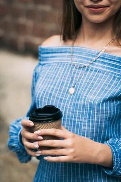 A female in a striped jumpsuit posing with a coffe cup Stock Photos