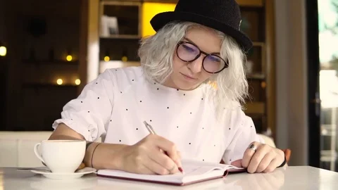 Female student doing her homework, writing in notebook Stock Footage 83880305