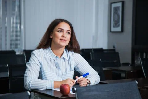 Female student in empty classroom sit and listen carefully 库存照片