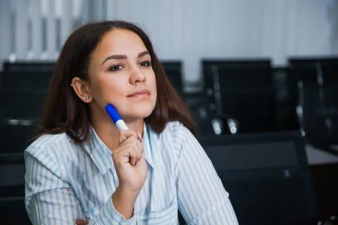 Female student in empty classroom sit and listen carefully Stock Photos