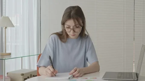 Female student with glasses taking notes Stock Footage 263701618