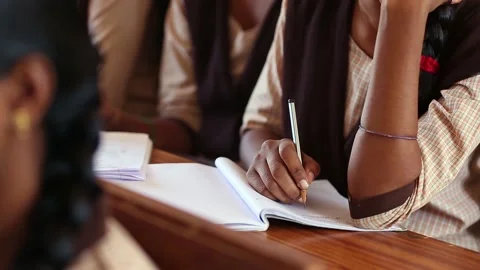 Female student hand writing in notebook on desk with pencil Stock Footage 229936731