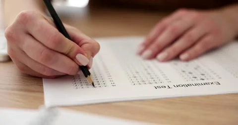 Female student highlights correct answer on test paper sheet Stock Footage 238509331