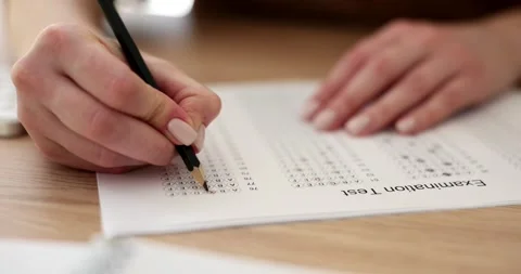 Female student highlights correct answer on test paper sheet Stock Footage 278976752