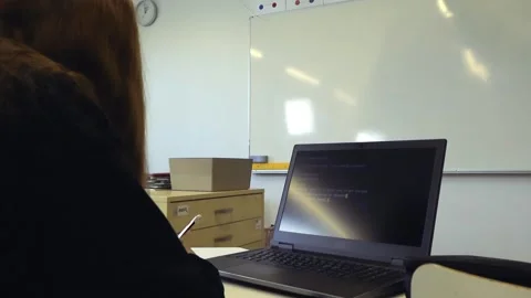 Female student learning to code with AI in a bright classroom Stock Footage 345529932