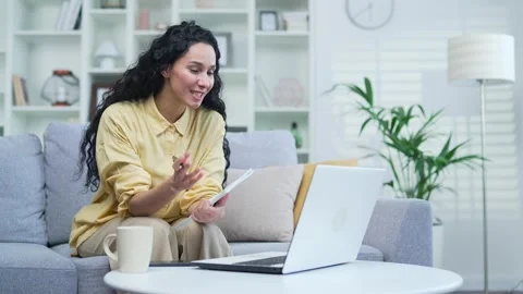 Female student listens to online e-learning of a remote teacher while sitting  Stock Footage 244451374