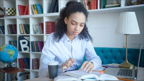 Female student making a note while preparing for exams in university library Stock Footage 104407469