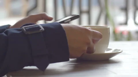 Female student messaging and drinking coffee in city cafe during her break Stock Footage 67061098