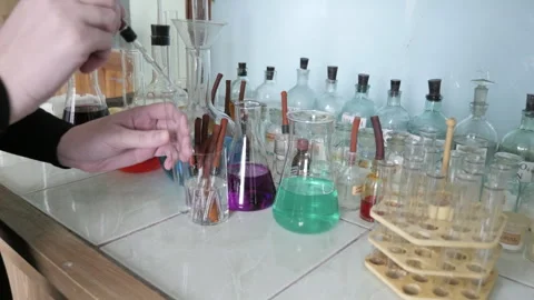 Female Student Or Teacher Doing Chemical Experiment In The Laboratory Video stock 328609798