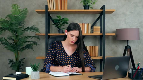 Female student performs practical task think solution problem write in notebook Stock Footage 139912968