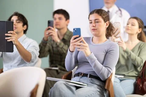 Female student scanning qr code in lecture hall Stock Photos