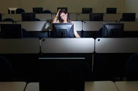 Female Student Scratching Head While Looking At Computer Stock Photos