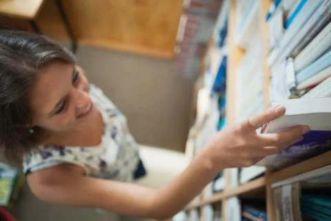 Female student selecting book in the library Stock Photos