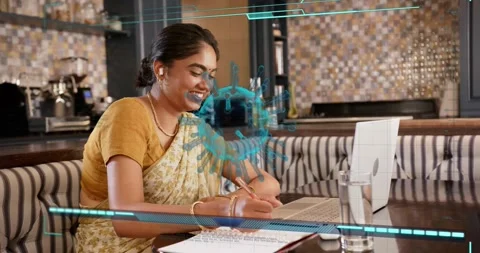 Female student sitting at cafe table, laptop activating blue 3D model, writing Stock Footage 321302072