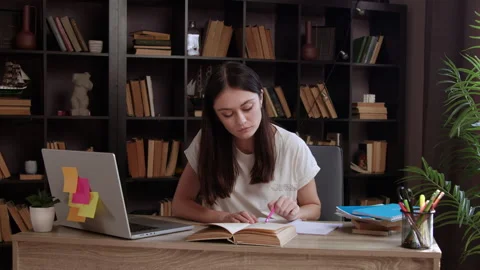 Female student sitting in library doing homework and preparing for college exam Video stock 304952767