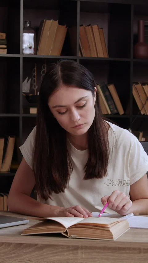 Female student sitting in library doing homework and preparing for college exam Video stock 305408467