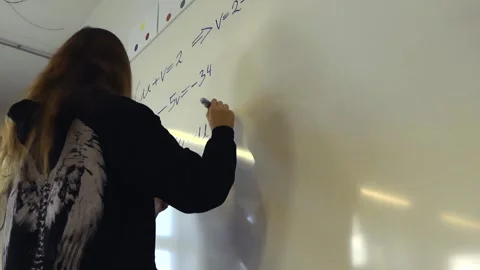 Female student solving algebra equations on whiteboard 库存影片 344105043
