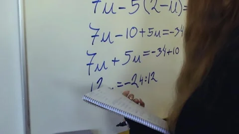 Female student solving complex algebra equation on whiteboard Stock Footage 344104953