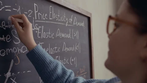 Female Student Solving Economics Problem on Chalkboard Stock Footage 332287692