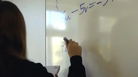 Female student solving a system of linear equations on a whiteboard Видео 345185673