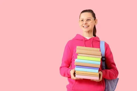 Female student with stack of books on pink background Stock Photos