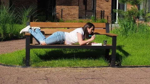 Female student studying on bench at campus Stock Footage 248275467