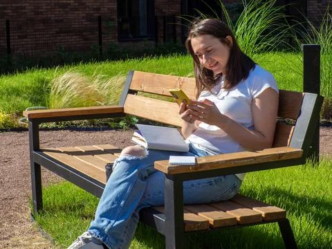 Female student studying on bench at campus Stock Photos