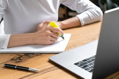 Female student is studying in a library using a laptop. Stock Photos
