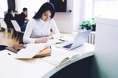 Female student taking notes in notebook Stock Photos