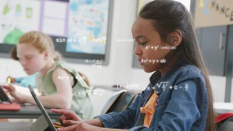 Female student typing on tablet in classroom, tapping sparking math overlays Stock Footage 335235875