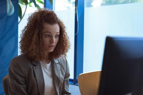 Female student using desktop computer while sitting by window Stockfoto's