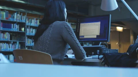 Female student works on a computer in library 4K Stock Footage 47008509