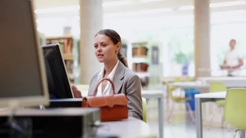 Female student works at computer in library Stock Footage 341426220